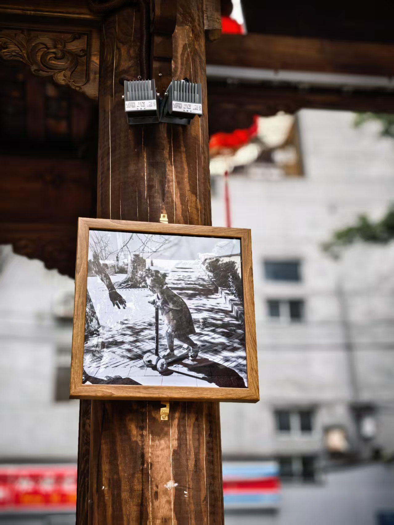 A black-and-white photo framed on a wooden pillar