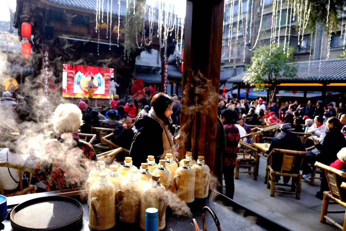 Steam rising off woven kettle flasks as the courtyard fills